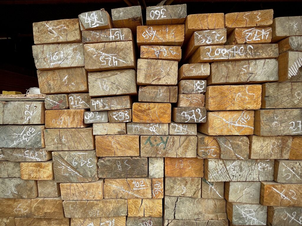 pexels-photo-12142000-12142000 Close-up of numbered wooden planks stacked in a warehouse, showcasing timber storage and organization.